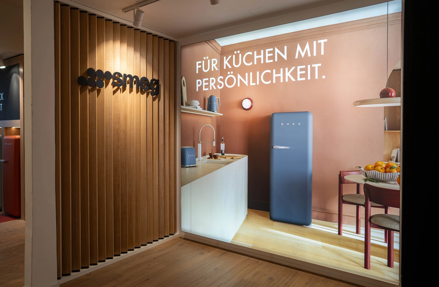 Heinrich Buchholz – Holzbearbeitung – Detailaufnahme eines Warendisplays mit leichten, naturbelassenen Holzkisten auf einem dunklen Regal zur Präsentation gefalteter Kleidung.