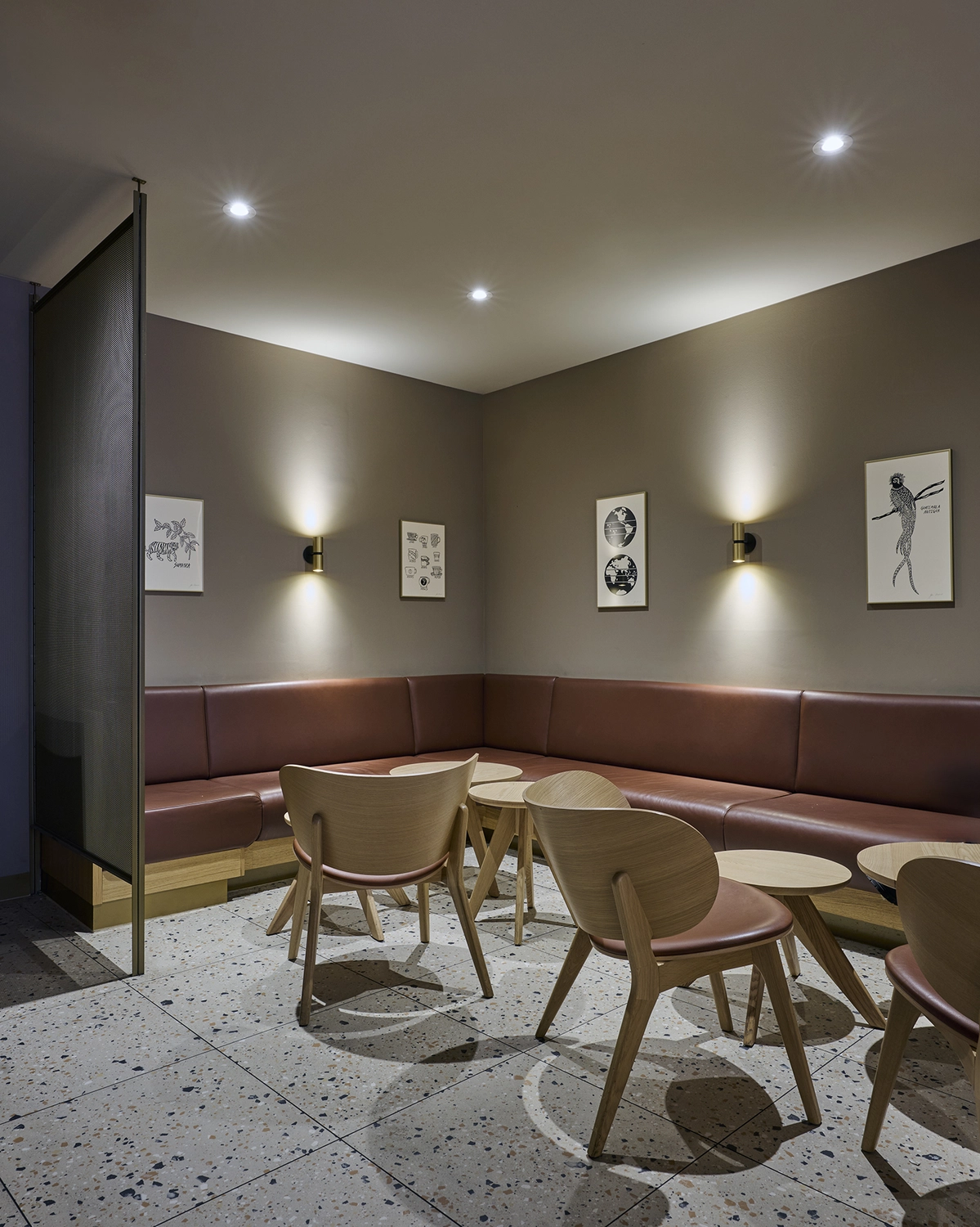 Heinrich Buchholz-Holzbearbeitung-Modernes Café-Interieur mit hellblauer vertikaler Lamellen-Servicetheke, dunkler Marmorarbeitsplatte und warmer LED-Basisbeleuchtung, vor einer dunkelgrünen Wand und einer maßgefertigten, passenden Tür mit rundem Bullaugenfenster.
